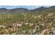 Majestic aerial view capturing the home nestled in a lush forest with rolling hills, offering privacy and stunning natural beauty at 11798 Ridge Rd, Golden, CO 80403