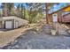 View of detached garage and house with gravel driveway at 11798 Ridge Rd, Golden, CO 80403