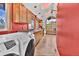 Bright, airy kitchen with red walls, wooden cabinets, stainless appliances, and laundry area at 11798 Ridge Rd, Golden, CO 80403