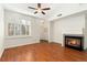 Bright living room with a fireplace, hardwood floors, and large window with plantation shutters at 6480 Silver Mesa Dr # B, Highlands Ranch, CO 80130