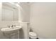 Well-lit powder room featuring a pedestal sink, stylish fixtures, and a white toilet for a clean and modern look at 6480 Silver Mesa Dr # B, Highlands Ranch, CO 80130