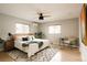 Bright bedroom featuring hardwood floors, a ceiling fan, a large window, and neutral decor at 11673 W 28Th Ave, Lakewood, CO 80215