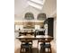 Open dining room area with a wooden table, modern lighting, and light hardwood floors underneath a skylight at 11673 W 28Th Ave, Lakewood, CO 80215