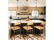Kitchen island with stylish seating, quartz countertops, modern lighting, and stainless steel appliances at 11673 W 28Th Ave, Lakewood, CO 80215