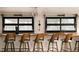 Stylish lounge area features bar seating with wood chairs and sleek black windows at 11673 W 28Th Ave, Lakewood, CO 80215
