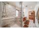 Bathroom with walk-in shower with built in bench and a view into bedroom at 5846 S Pike Dr, Larkspur, CO 80118