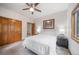 Comfortable bedroom featuring neutral tones, carpet, ceiling fan, and wood trim throughout at 5846 S Pike Dr, Larkspur, CO 80118