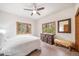 Cozy bedroom offering natural light, carpet flooring, ceiling fan, and wood-trimmed windows at 5846 S Pike Dr, Larkspur, CO 80118