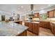 Spacious open kitchen with stainless steel appliances, island cooktop, and stone countertops at 5846 S Pike Dr, Larkspur, CO 80118