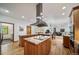 Open-concept kitchen with island cooktop, custom cabinets, and stainless steel appliances at 5846 S Pike Dr, Larkspur, CO 80118