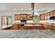 Bright kitchen features custom wood cabinets, stainless steel appliances, and a stone island at 5846 S Pike Dr, Larkspur, CO 80118