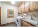Convenient laundry room featuring modern washer/dryer, storage, and a sink at 5846 S Pike Dr, Larkspur, CO 80118