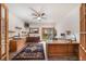 Home office with wood floors, ceiling fan, shelving, and sliding glass door to backyard at 5846 S Pike Dr, Larkspur, CO 80118