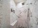 Elegant shower showcasing pebble accent wall, marble tile, bench, and multiple shower heads at 5846 S Pike Dr, Larkspur, CO 80118