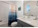 Bathroom features a single sink vanity, modern fixtures, tub, and artistic curtain at 2127 Alcott Way, Broomfield, CO 80023