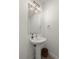Compact powder room with a pedestal sink, modern lighting, and a neutral color palette at 2127 Alcott Way, Broomfield, CO 80023