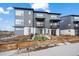 Modern townhome with a gray exterior, small balconies, and a charming front yard with a wooden fence at 2127 Alcott Way, Broomfield, CO 80023