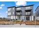 Contemporary townhome with a gray exterior, small balconies, and a charming front yard with a wooden fence at 2127 Alcott Way, Broomfield, CO 80023