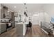 Bright kitchen with an island, stainless steel appliances, and modern pendant lighting at 2127 Alcott Way, Broomfield, CO 80023
