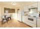 White kitchen with breakfast nook and modern appliances at 2131 Coronado Pkwy # A, Denver, CO 80229