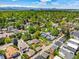 This aerial shot offers a glimpse of a neighborhood surrounded by lush greenery and a beautiful mountain range at 1160 S Steele St, Denver, CO 80210