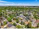 Wide aerial shot displaying a neighborhood filled with lush trees and various architectural styles of beautiful residences at 1160 S Steele St, Denver, CO 80210