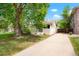 Charming single-Gathering home featuring a large tree and long driveway on a sunny day at 1160 S Steele St, Denver, CO 80210