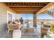 Covered back patio with comfortable seating and string lights offers a cozy outdoor living space at 17851 Herrera Dr, Parker, CO 80134