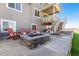 Outdoor patio with stone fire pit and Adirondack chairs, steps leading to a covered balcony with seating at 17851 Herrera Dr, Parker, CO 80134