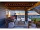 Relaxing covered patio with comfortable seating, stylish decor, and a view of the well-manicured backyard at 17851 Herrera Dr, Parker, CO 80134