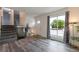 Open-concept living area with gray wood flooring, stairs with black metal railing and large window at 2493 S Kalispell Cir, Aurora, CO 80013