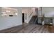 Bright living room with modern gray wood floors, stairs with black metal railing and view to kitchen at 2493 S Kalispell Cir, Aurora, CO 80013