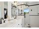 Bathroom featuring double sinks, shower with glass door and tiled floor at 1299 Newton St, Denver, CO 80204