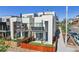 Modern home exterior featuring white siding, balconies, fenced yard and street view at 1299 Newton St, Denver, CO 80204