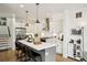 Modern kitchen with white cabinets, island with seating, and stainless steel appliances at 1299 Newton St, Denver, CO 80204