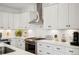 Bright, modern kitchen featuring white cabinets, quartz countertops and stainless steel range hood at 1299 Newton St, Denver, CO 80204