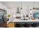 Modern kitchen with stainless steel appliances, white cabinets, and a gray kitchen island at 1299 Newton St, Denver, CO 80204