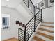 Modern staircase featuring sleek black railings and natural wood steps at 1299 Newton St, Denver, CO 80204