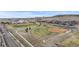 Aerial view of a neighborhood park, baseball field, and grassy areas amid residential homes and scenic hills at 10204 Ridgegate Cir, Lone Tree, CO 80124