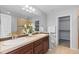 Bathroom with a double sink vanity, walk-in closet, and a glass-enclosed shower at 10204 Ridgegate Cir, Lone Tree, CO 80124