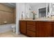Bathroom featuring a double sink vanity with dark cabinets and a tiled shower at 10204 Ridgegate Cir, Lone Tree, CO 80124