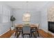 Dining room with modern chandelier, wooden table, and a view of the stone fireplace at 10204 Ridgegate Cir, Lone Tree, CO 80124