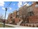 Beautiful brick townhomes showcase manicured landscaping, entry stairs, and classic exterior architecture at 10204 Ridgegate Cir, Lone Tree, CO 80124