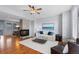 Bright living room with hardwood floors, stone fireplace, ceiling fan, and view into dining area at 10204 Ridgegate Cir, Lone Tree, CO 80124