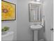 Clean powder room featuring pedestal sink, decorative mirror, and gray walls at 10204 Ridgegate Cir, Lone Tree, CO 80124
