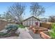 Landscaped backyard with raised garden beds, stone pathway, and a detached garage at 2039 S Corona St, Denver, CO 80210