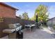 Outdoor patio area featuring a grill, dining table, and well-maintained landscaping at 2039 S Corona St, Denver, CO 80210