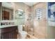 Modern bathroom with glass-enclosed shower, neutral tile, glass shelves, and granite vanity at 2039 S Corona St, Denver, CO 80210