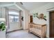 Cozy Bedroom with wooden crib, soft natural light, and playful wall decor at 2039 S Corona St, Denver, CO 80210
