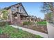 A charming brick home showcases professionally landscaped grounds on a tree lined street at 2039 S Corona St, Denver, CO 80210